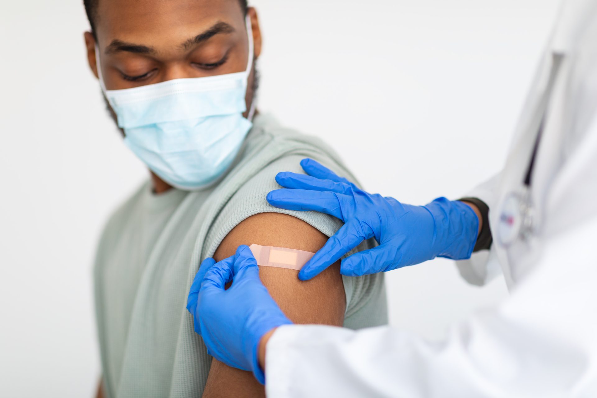 Man,Getting,Vaccinated,Against,Covid-19,,Doctor,Applying,Plaster,,White,Background
