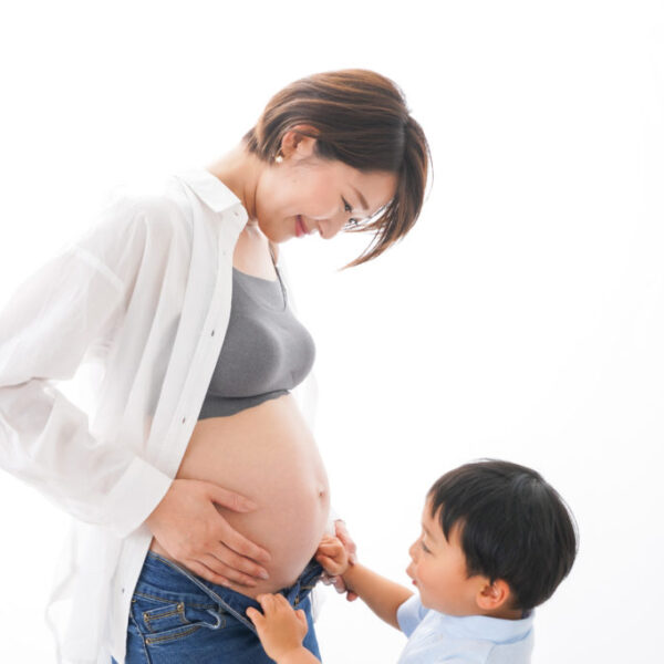 asian pregnant mom with son looking at her belly